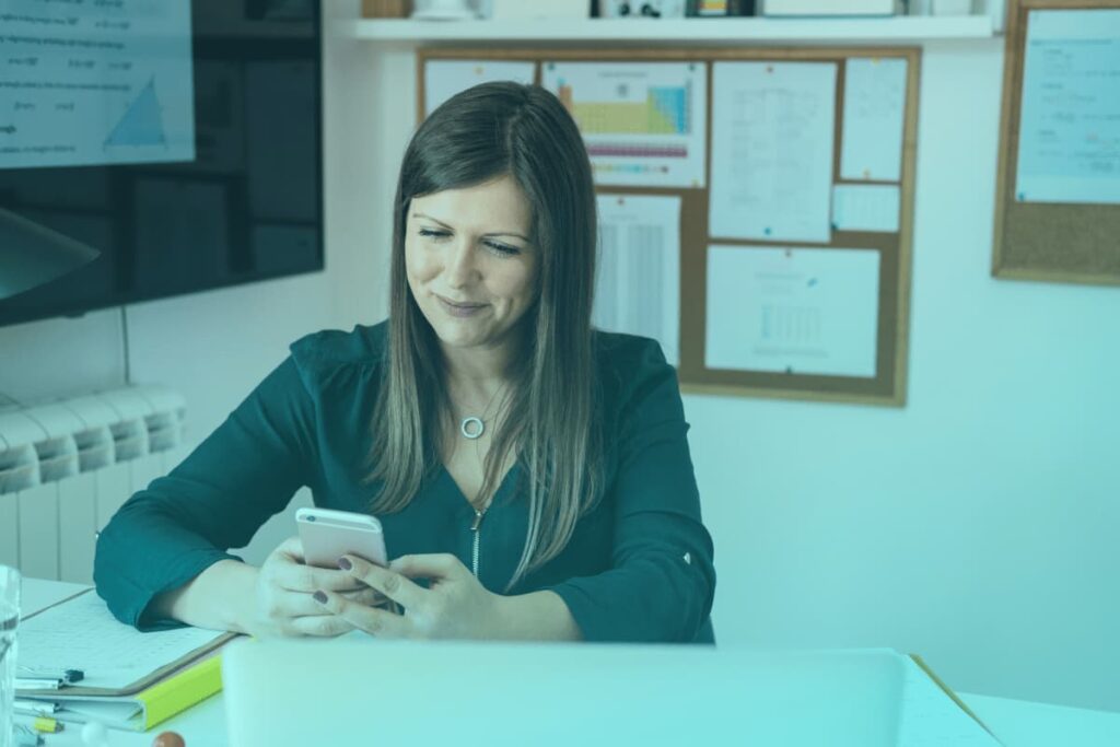 female teacher using phone in classroom